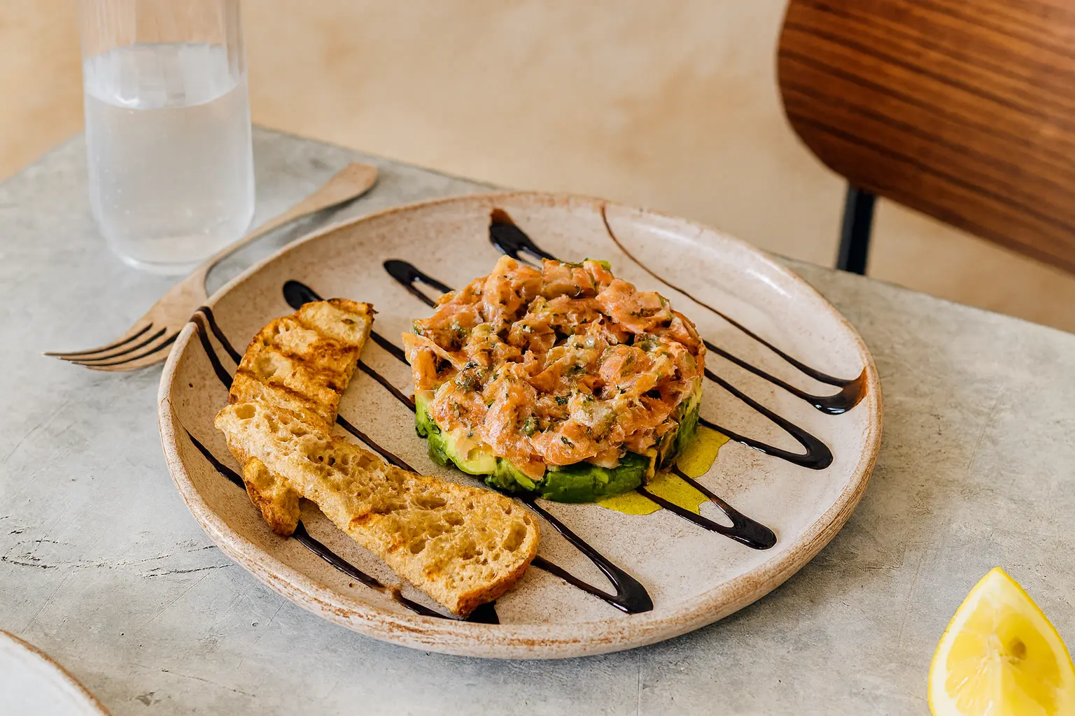Salmon and avocado tartare stacked in a ring mould, finished with dill and balsamic glaze, served with toasted ciabatta.