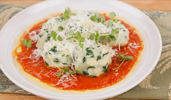 in the kitchen with stefano faita ricotta and spinach gnudi with roasted tomato sauce served on a white plate
